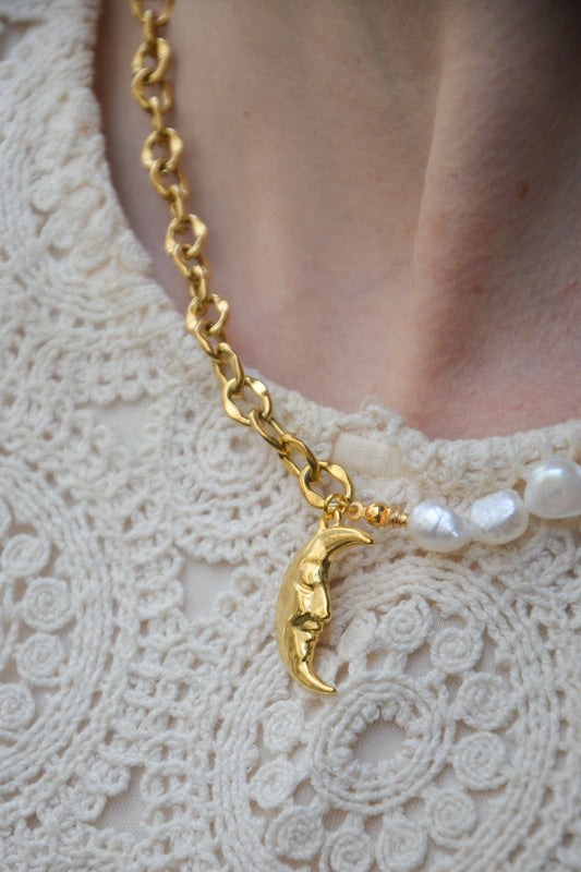 Collier Galene – Chaîne Dorée, Perles Blanches & Lune Dorée
Laissez-vous envelopper par la douceur et l'élégance du collier "Galene", inspiré de la nymphe grecque de la sérénité marine. Ce bijou délicat allie la pureté des perles blanches à l’éclat d’une chaîne dorée et d’un pendentif lune dorée, symbole de calme, de féminité et d’intuition.
Pensé comme un hommage à la tranquillité de la mer et à la lumière lunaire, le collier "Galene" apporte une touche de grâce naturelle à toutes vos tenues. Parfait