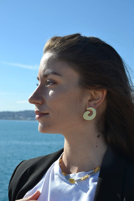 Boucles d'Oreilles Spirales - Élégance Intemporelle et Symbolisme Universel Découvrez l'élégance intemporelle et le symbolisme profond avec nos boucles d'oreilles Spirales, méticuleusement fabriquées à la main par nos artisans. Inspirées par le motif de la spirale, ces boucles d'oreilles sont une célébration de l'infini, de la croissance et de l'évolution.