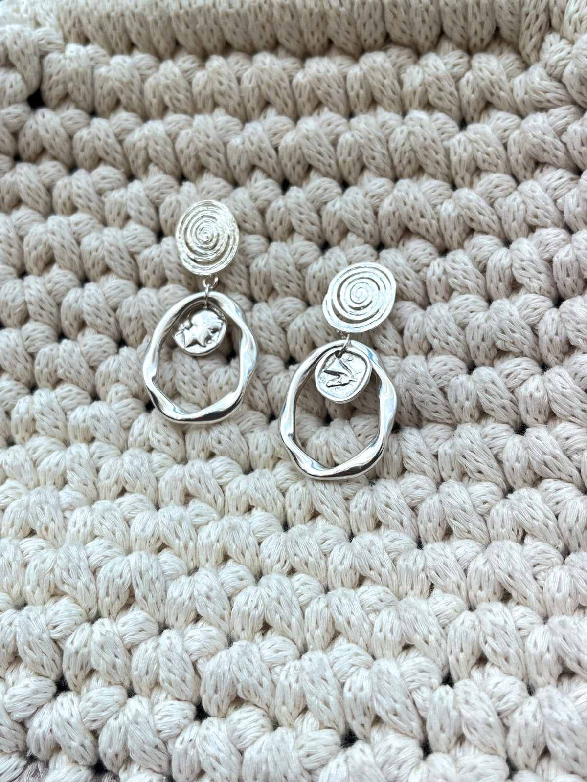 Némésis – Boucles d’Oreilles Argentées Spirales &amp; Pièces Antiques

Puissantes. Mystiques. Éternelles.

Les boucles Némésis tirent leur nom de la déesse grecque de la justice et de l’équilibre. Fusion parfaite entre héritage antique et design symbolique, elles arborent des spirales élégantes et des médaillons inspirés des pièces antiques, où se dessinent les silhouettes d’Athéna la sage et de Pégase, le messager ailé.