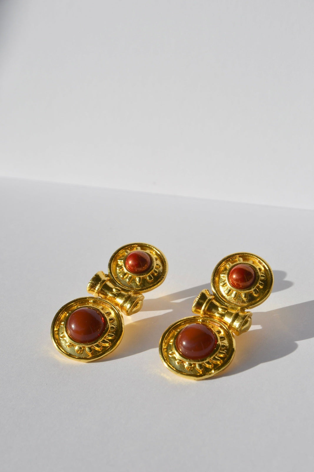 Boucles d'oreilles pendantes, plaquées or,en forme de bouclier, faites main par nos artisans.La divinité des festivités et de la floraison.Clips pour oreilles non percées