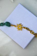 Bracelet Aélios – Turquoise Naturelle, Soleil Doré &amp; Chaîne

Inspiré du dieu grec du Soleil, "Aélios" est un bracelet lumineux qui unit la chaleur dorée du soleil à la fraîcheur vibrante de la turquoise naturelle. Mi-chaîne dorée, mi-pierres, il symbolise l’équilibre entre l’éclat solaire et l’énergie tellurique de la terre.

La turquoise, pierre de protection et d’apaisement, évoque les eaux claires, les étés infinis et les esprits libres. Le motif soleil en métal doré ajoute une touche sacrée et rayon