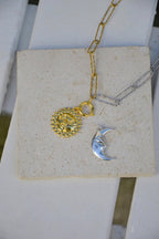 Portez l'équilibre céleste autour de votre cou avec le collier Séléné, une ode délicate à la danse éternelle entre la Lune et le Soleil. Composé de deux pendentifs fins – un croissant de lune argenté et un soleil doré éclatant – ce bijou symbolise le lien entre lumière et mystère, énergie et douceur.