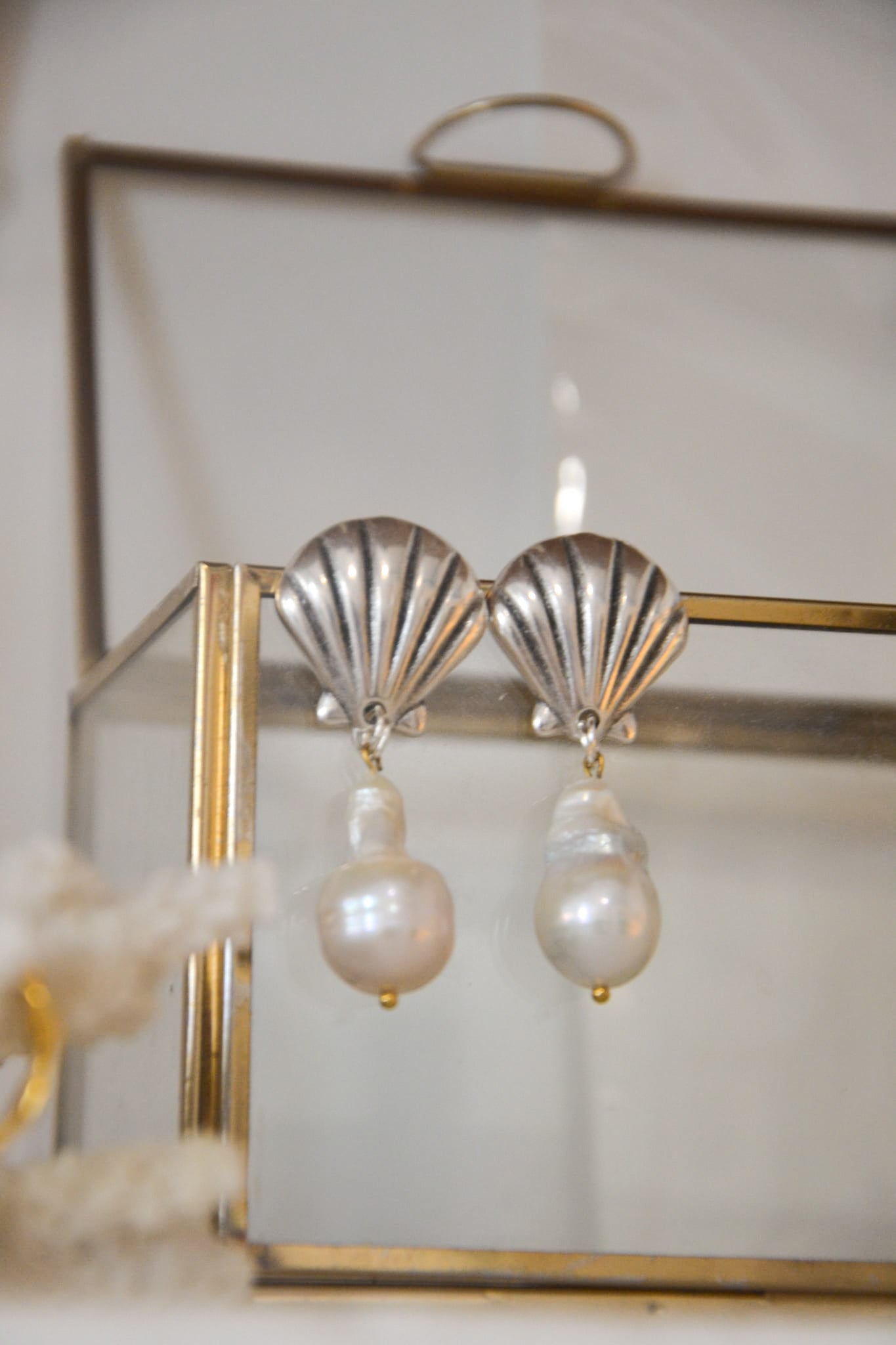 Nerida – Boucles d’oreilles perles &amp; coquillages inspirées des nymphes de la mer

Plongez dans l’élégance naturelle de la mer Égée avec Nerida, une paire de boucles d’oreilles qui rend hommage aux Néréides, les nymphes marines de la mythologie grecque. Chaque pièce marie l’authenticité d’un coquillage naturel à la douceur d’une perle nacrée, évoquant la beauté sauvage des fonds marins.