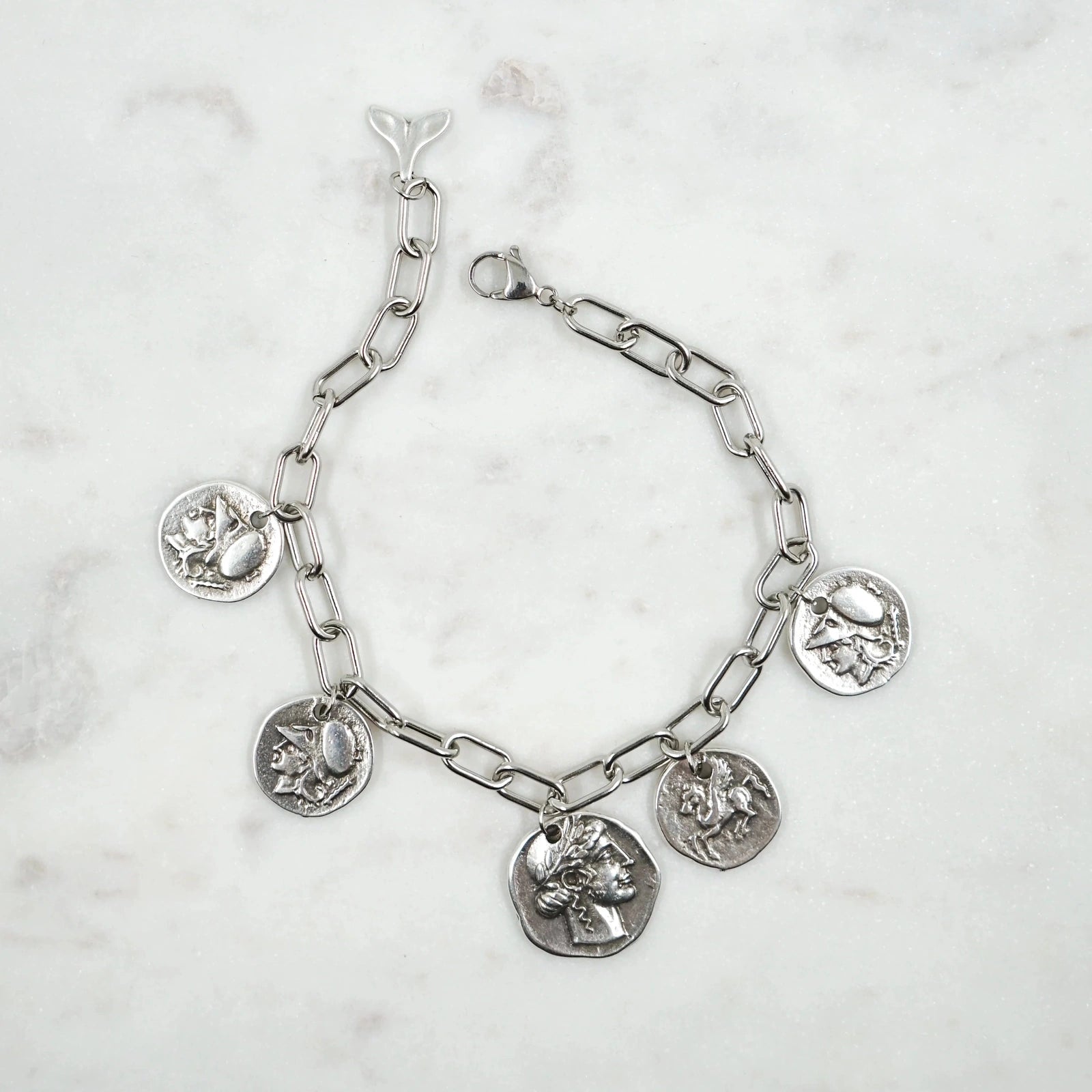 Bracelet Antiquité - Héritage Historique et Élégance Artisanale  Plongez dans l'histoire avec notre bracelet Antiquité, méticuleusement fabriqué à la main par nos artisans talentueux. Orné de pièces antiques double face, ce bracelet unique capture l'essence des légendes et des figures emblématiques de l'Antiquité.