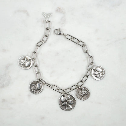 Bracelet Antiquité - Héritage Historique et Élégance Artisanale  Plongez dans l'histoire avec notre bracelet Antiquité, méticuleusement fabriqué à la main par nos artisans talentueux. Orné de pièces antiques double face, ce bracelet unique capture l'essence des légendes et des figures emblématiques de l'Antiquité.
