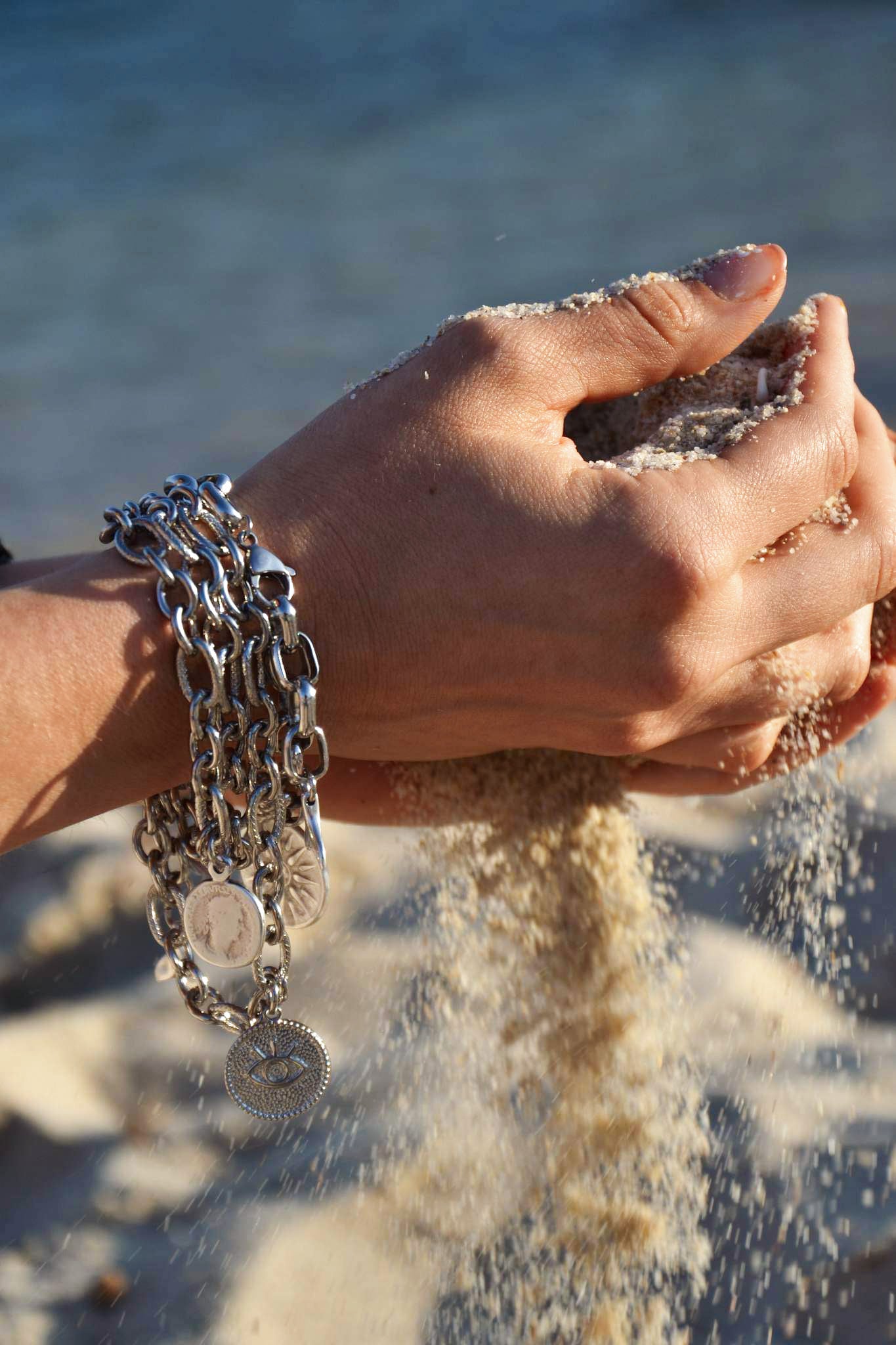 Bracelet argenté, décoré d'une pièce antique, fait main par nos artisans. La pièce antique symbolise le soleil de Vergina. C'est un symbole découvert par l'archéologue grec Manólis Andrónikos dans une tombe royale macédonienne attribuée au père d'Alexandre le Grand, Philippe II. Il s'agit d'une étoile ou d'un soleil stylisé, composé d'un rond entouré de seize rayons.